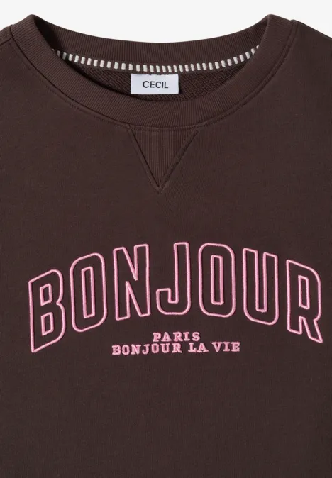 Ein brauner Pullover mit pinkem "BONJOUR"-Schriftzug, darunter "PARIS BONJOUR LA VIE" in Weiß, Label 'CECIL'.